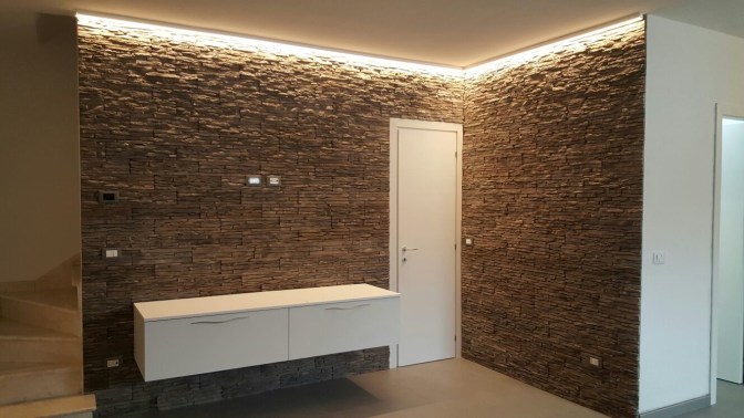 Una parete in Petra grigiofumo, illuiminata.